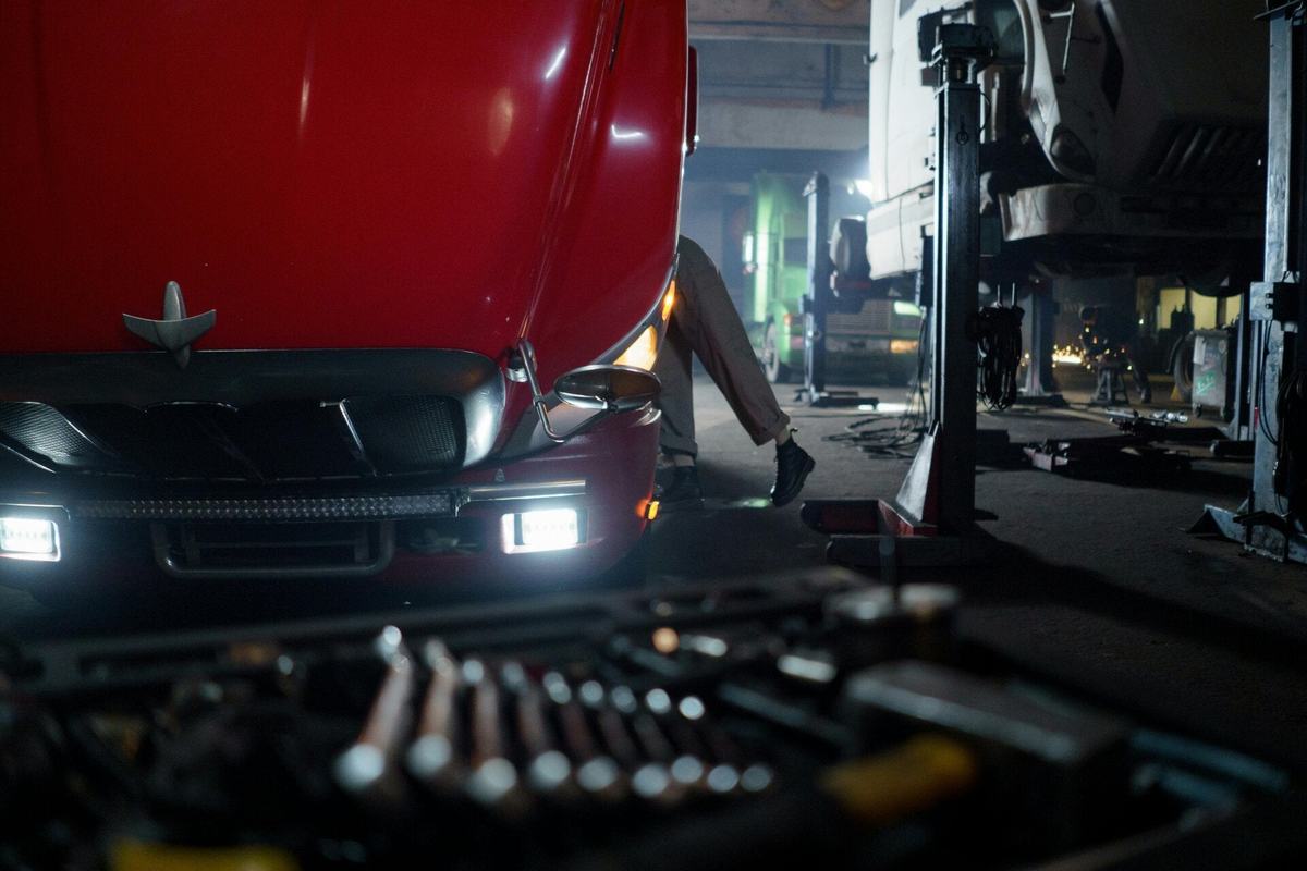 Socket set laid out in front of a red truck with its hood raised